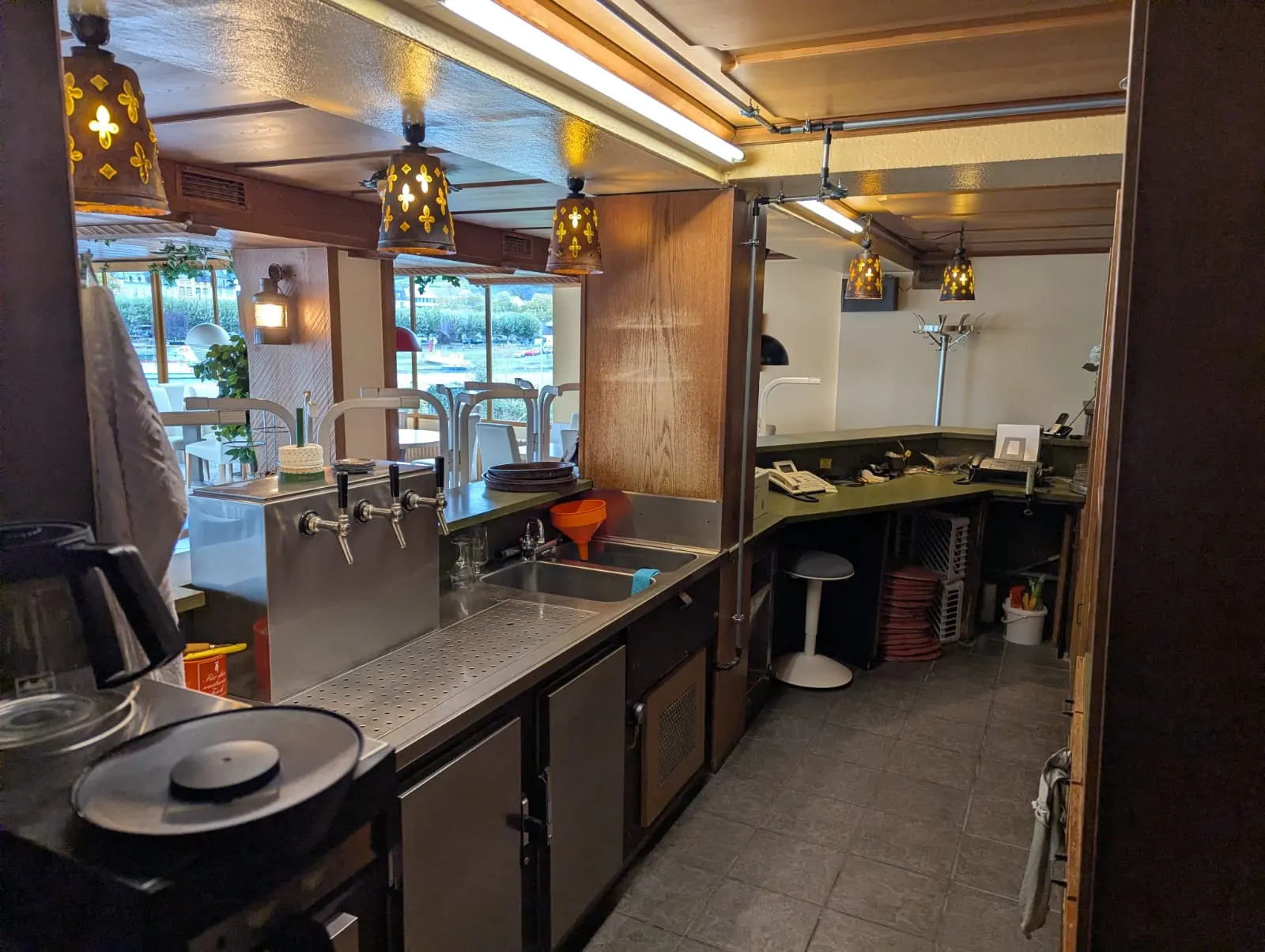 Innenseite der Restauranttheke mit Zapfhähnen, Spülbecken und Blick in den Gastraum